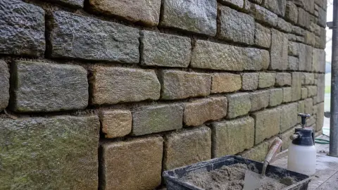 mur en pierre dejointoye et humidifie avant rejointoiement a la chaux