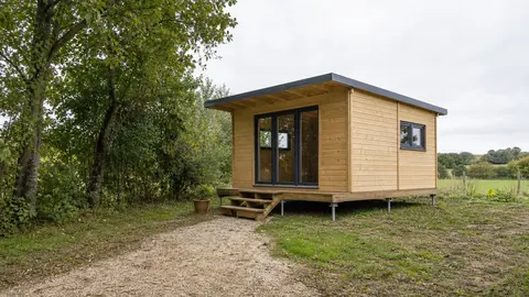 Chalet léger posé sur plots dans un terrain arboré