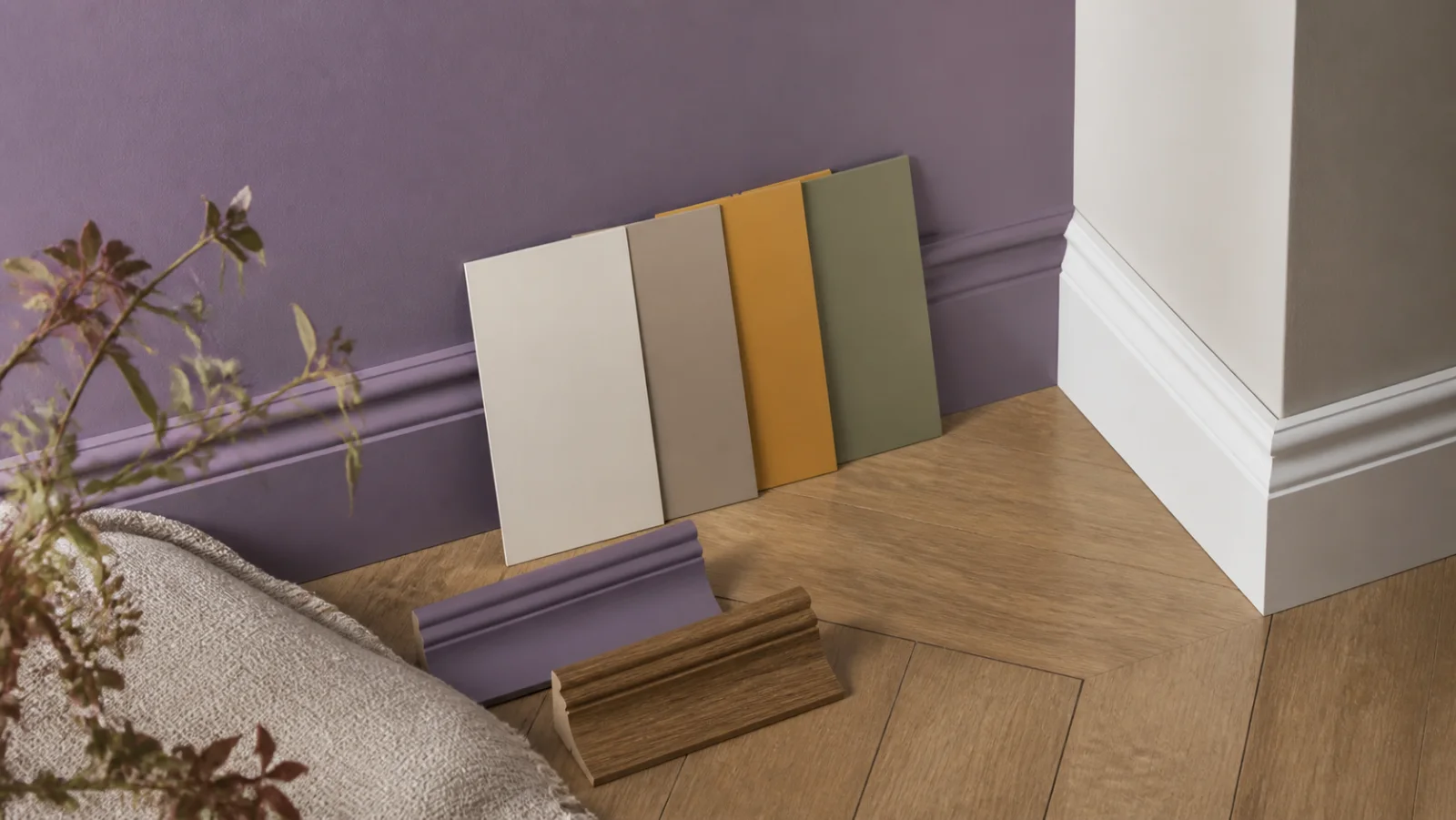 Mur violet avec plinthes, sol bois et échantillons de couleurs complémentaires